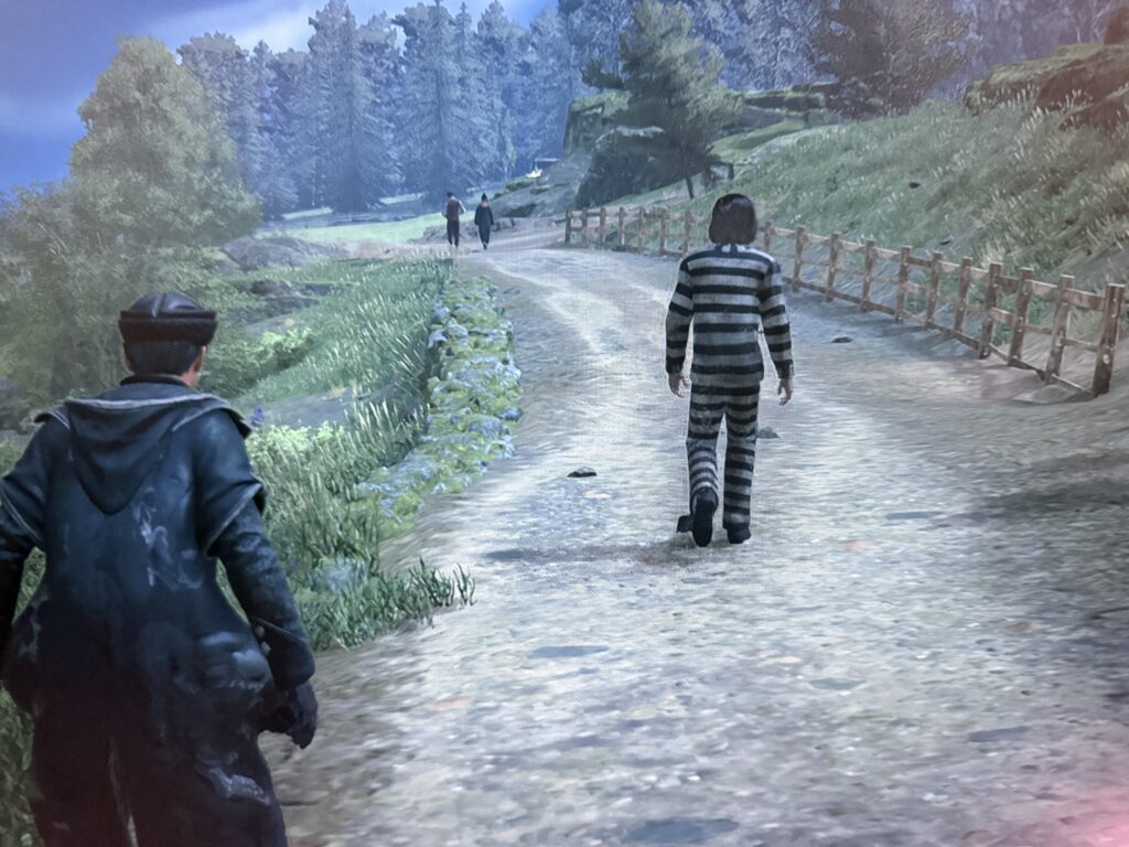 Hogwarts Legacy player stands near Azkaban prisoner NPC in dark prison cell