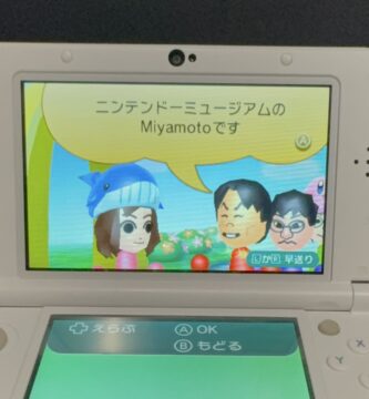 Visitors holding 3DS consoles at the Nintendo Museum in Kyoto, excited about StreetPass Miis featuring Shigeru Miyamoto