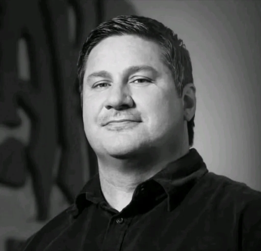 Portrait of Bill Petras, Blizzard art director, with Overwatch and World of Warcraft artwork in the background