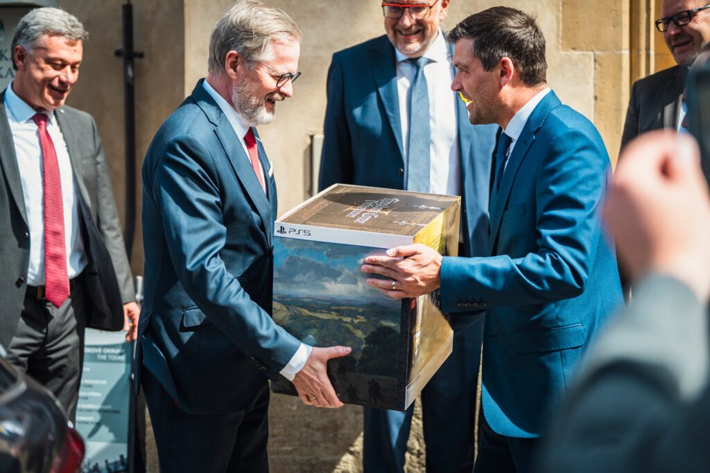 Czech Prime Minister Petr Fiala smiling while receiving Kingdom Come: Deliverance 2 Collector’s Edition from Mayor Lukáš Seifert