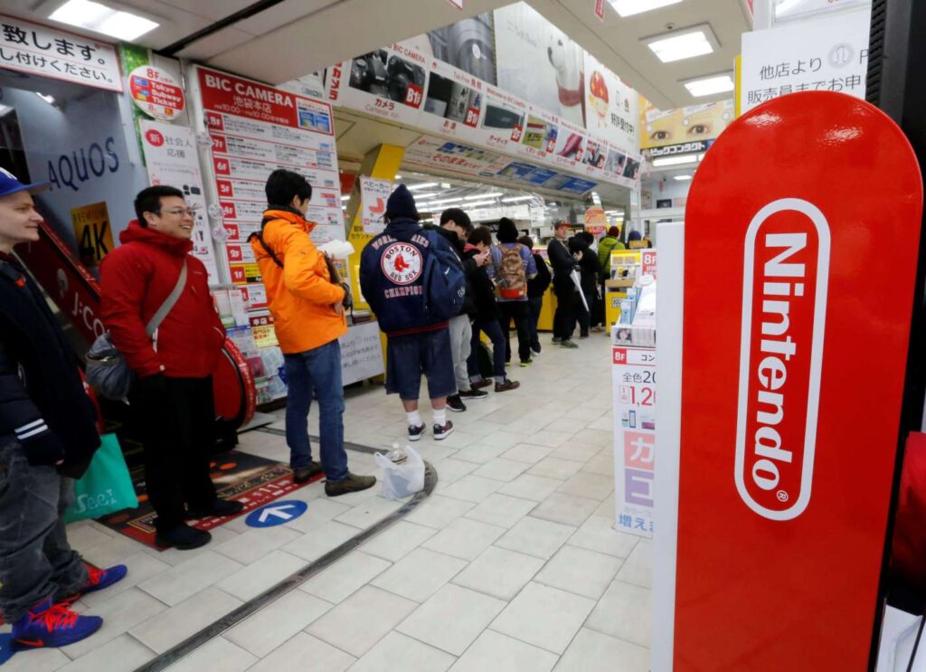 Nintendo Switch 2 console with Japanese gamers lining up outside a store