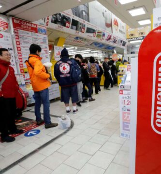 Nintendo Switch 2 console with Japanese gamers lining up outside a store