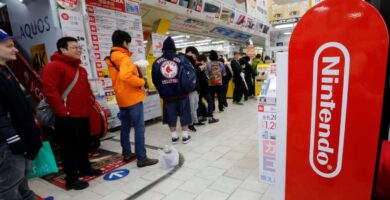 Nintendo Switch 2 console with Japanese gamers lining up outside a store