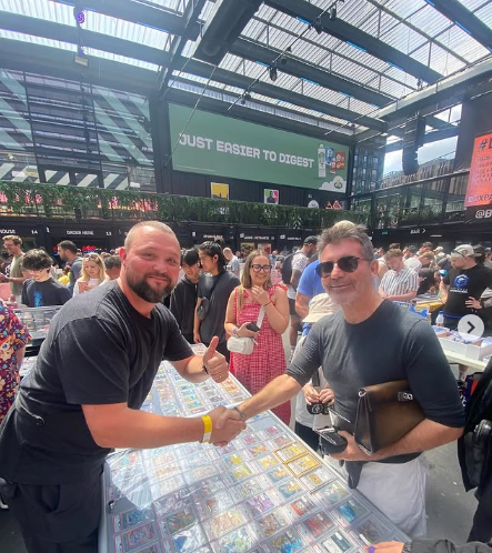 Simon Cowell shakes hands with a Pokémon card vendor at the London Cards & Collectibles Convention