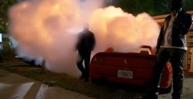Travis Scott standing beside a car with GTA VI6 license plate in 2000 Excursion music video